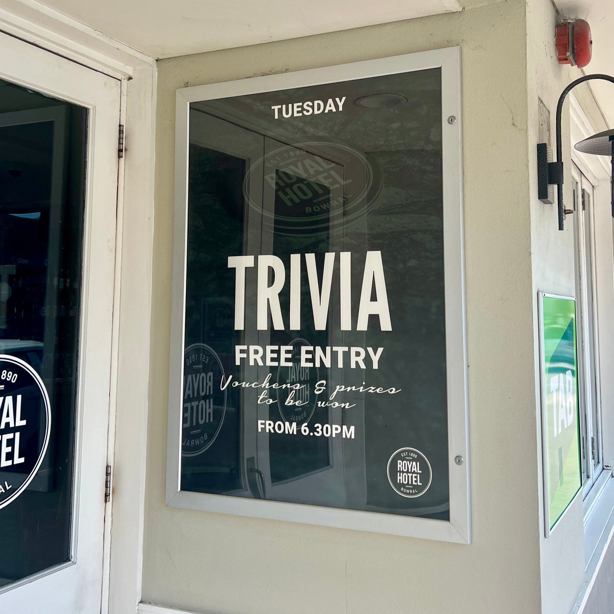Trivia event poster on a wall at the Royal Hotel, with 'Royal Hotel' branding visible.