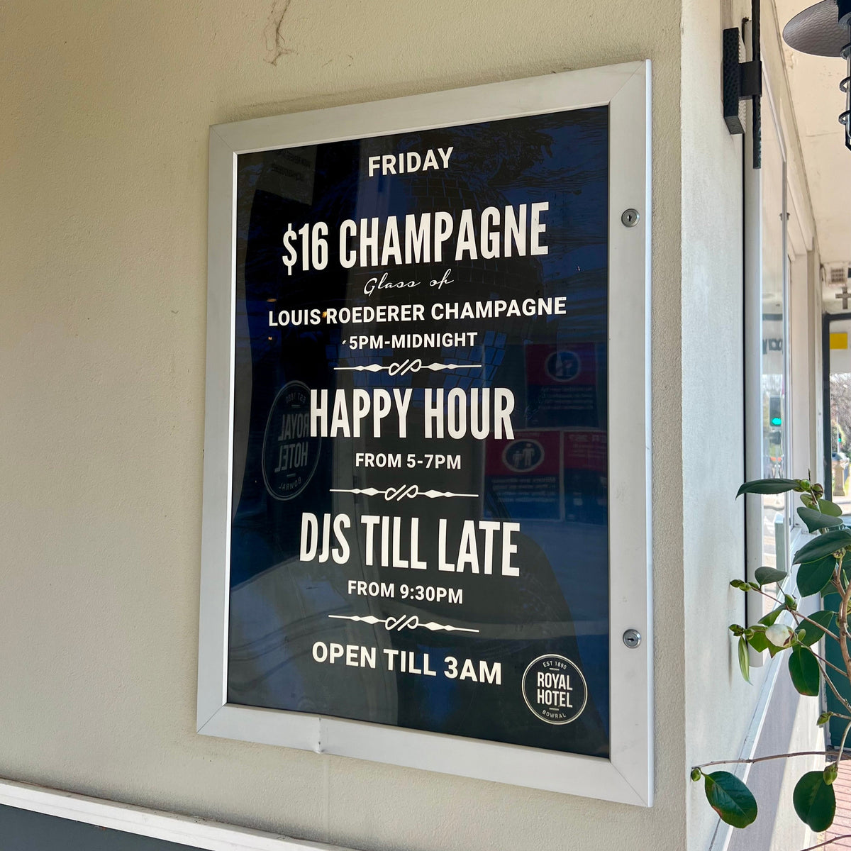 Promotional sign for a bar event with drink specials and hours displayed.