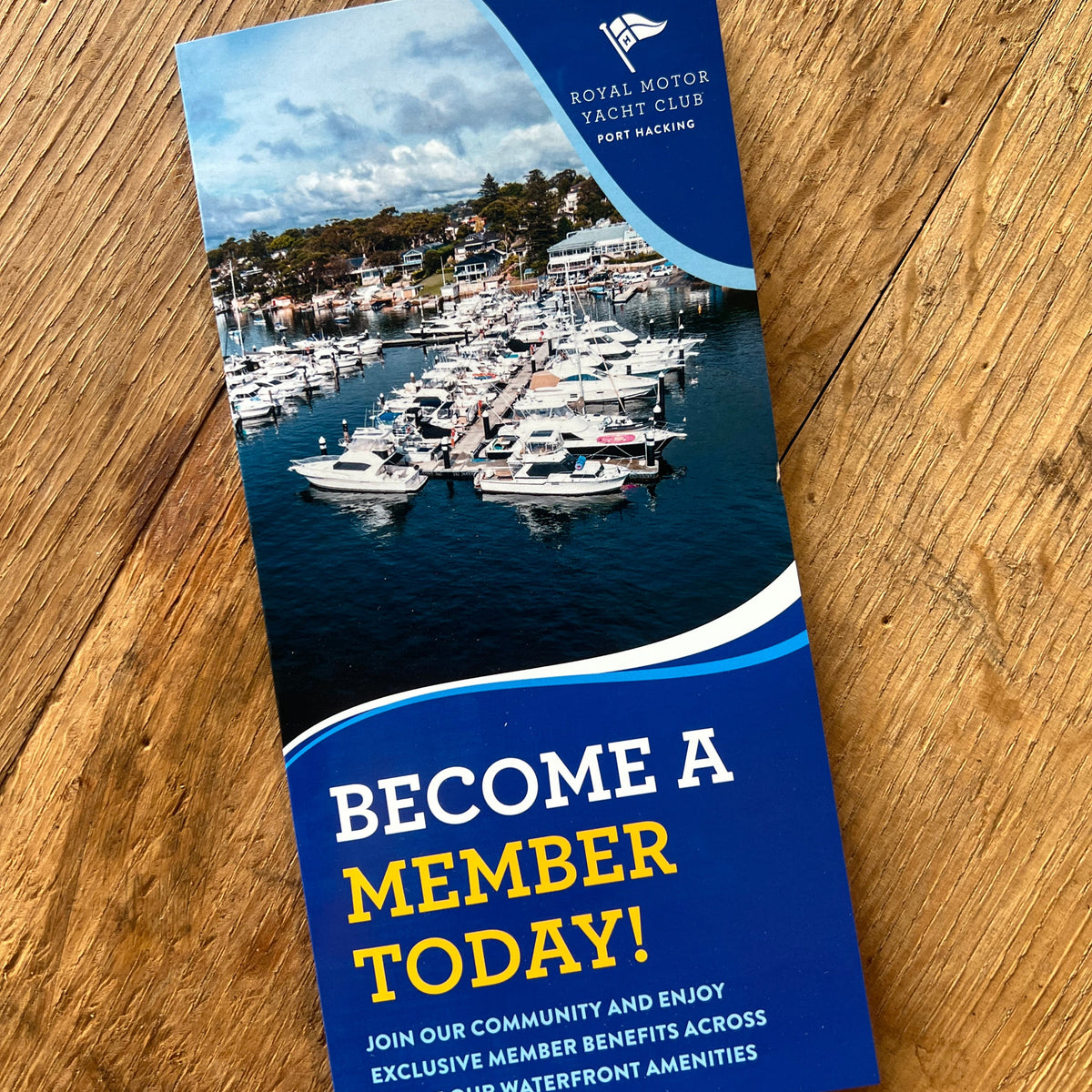 Brochure with marina image and text on a wooden surface