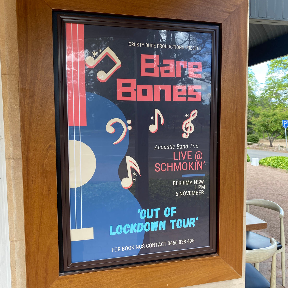 Framed poster with 'Bare Bones' design on a wooden surface