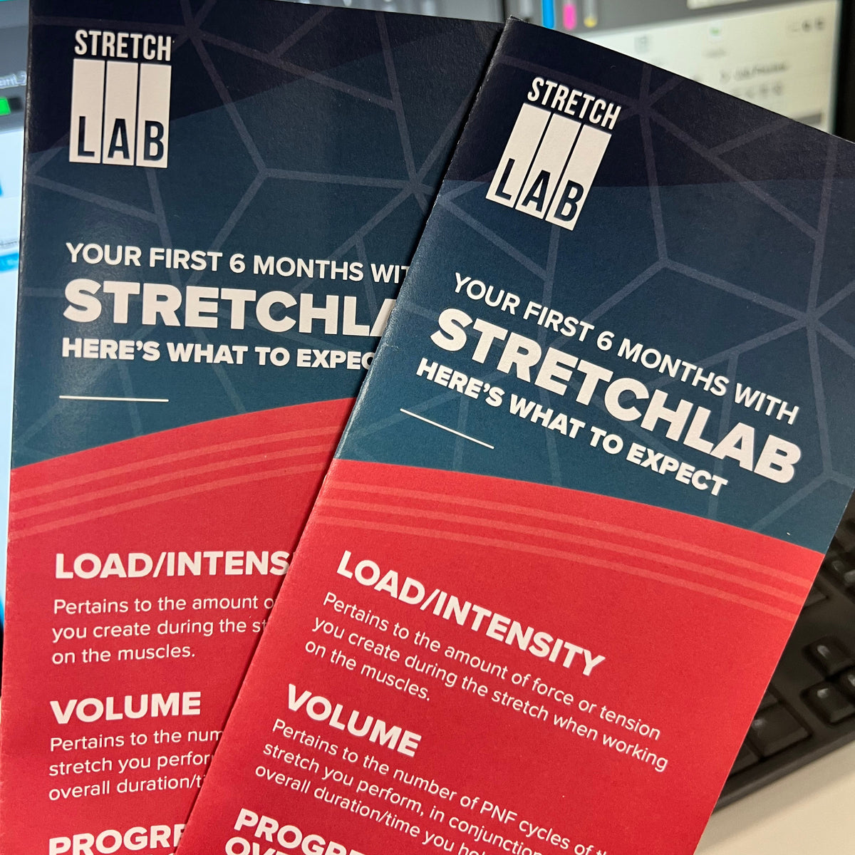 Two Stretch Lab brochures on a blurred background